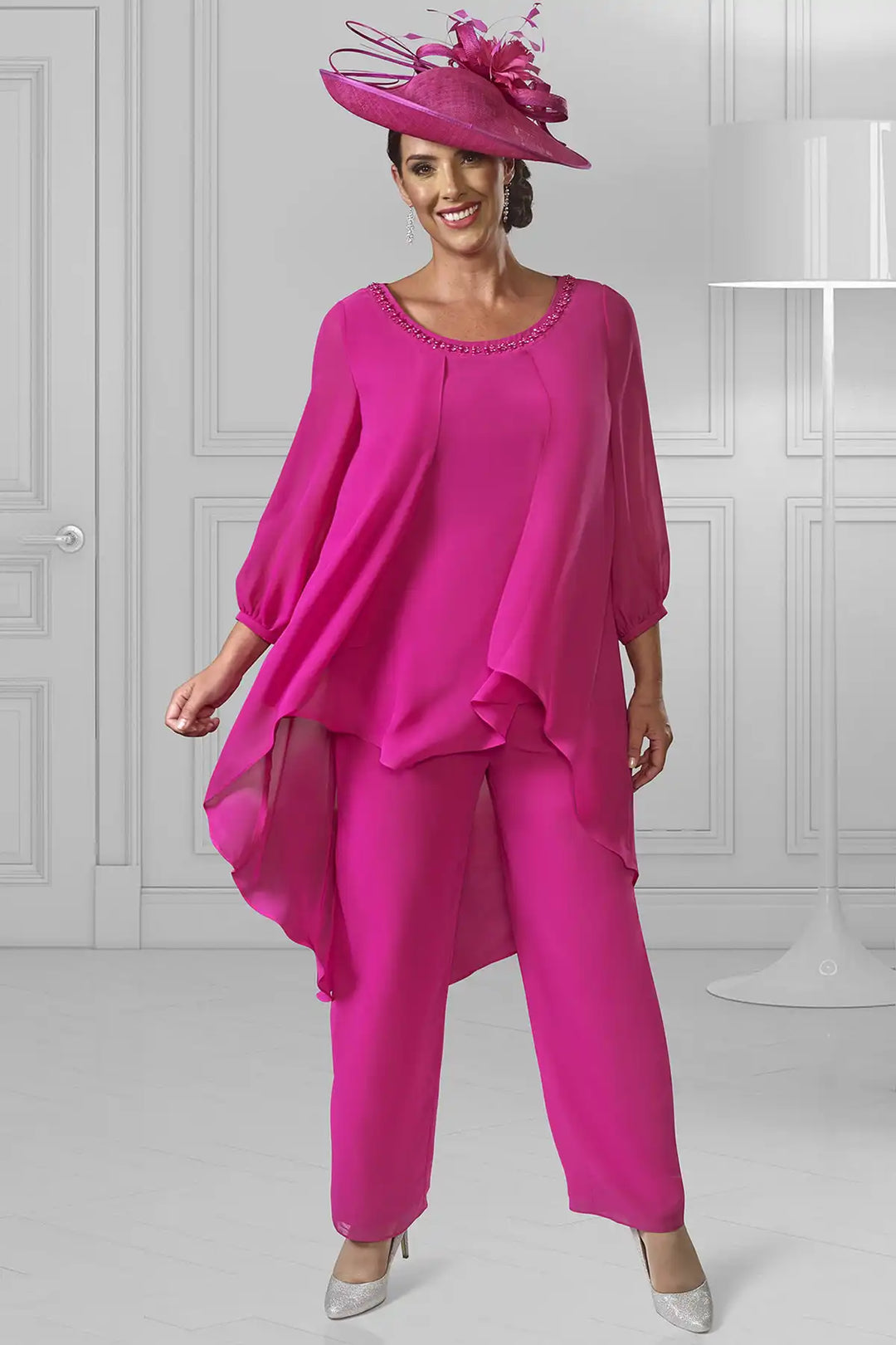Woman wearing a Dressed Up by Veromia DU597E two-piece outfit featuring a flowy chiffon top with elegant sleeves, a crystal-embellished neckline, and an asymmetrical hemline, paired with tailored crepe trousers.