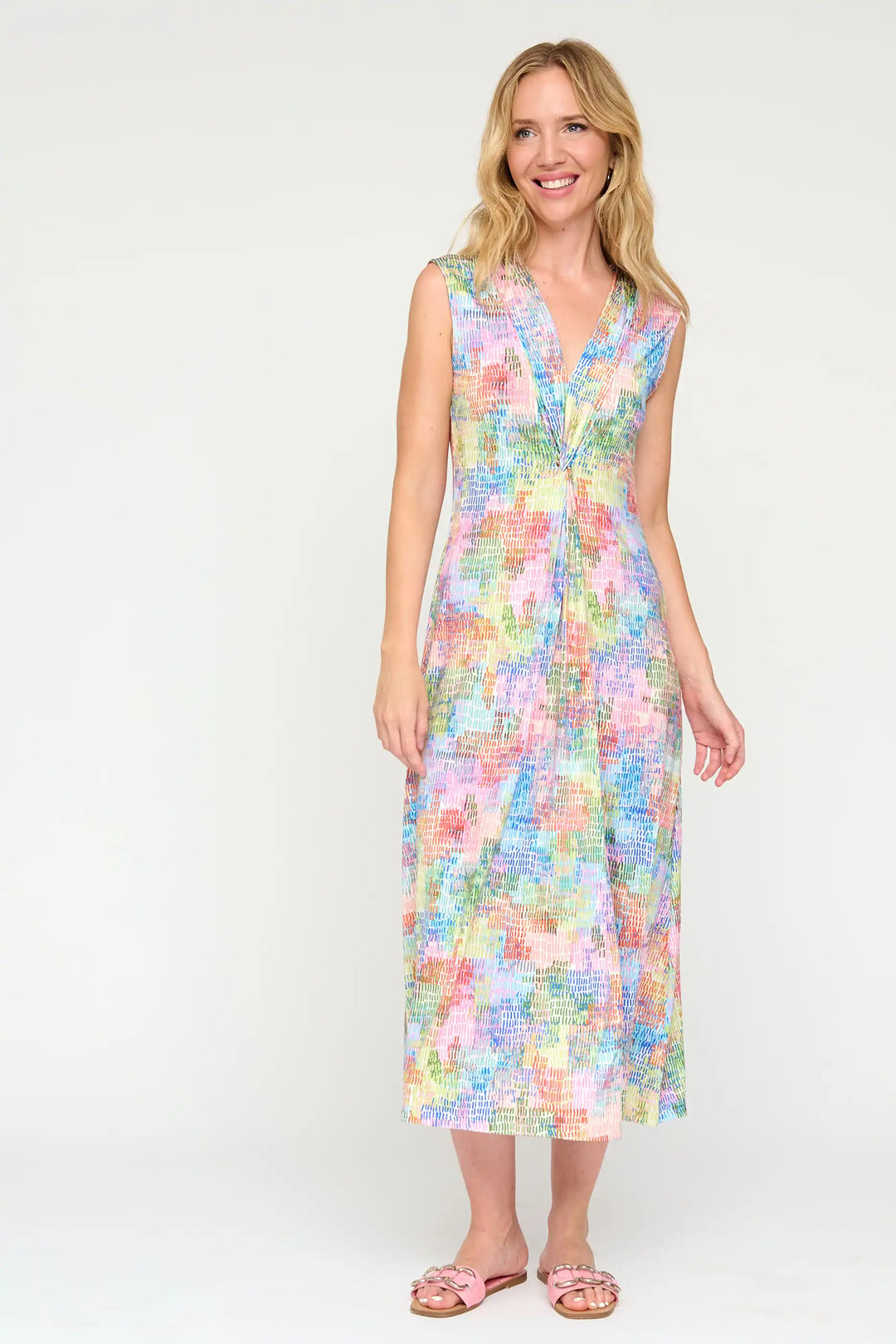 Model in the 'Veronica24' style midi dress, smiling, with a pastel-coloured abstract print, V-neckline, and a waist detail, paired with light pink sandals.
