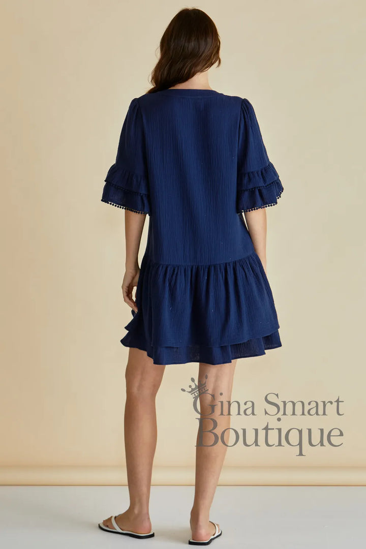 Betty Basics Malibu Dress back view of navy blue mini dress with tiered ruffle sleeves and a ruffled drop-waist skirt.  Available at Gina Smart Boutique