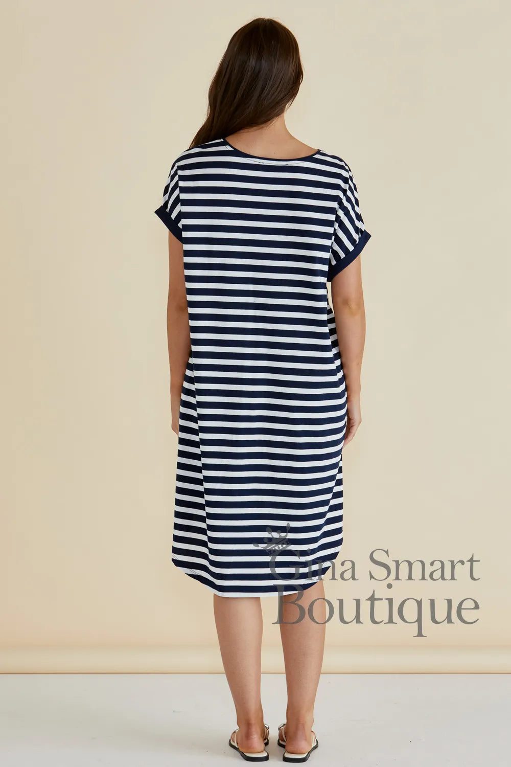 Betty Basics Maxine T-Shirt Dress rear view is a navy and white horizontal striped t-shirt dress with a high-low hem - available at Gina Smart Boutique