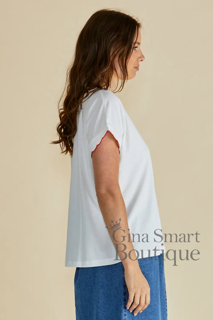 Betty Basics Sloane White Scallop Tee side view is a white crew neck t-shirt with red-trimmed scalloped sleeves.  Available at Gina Smart Boutique