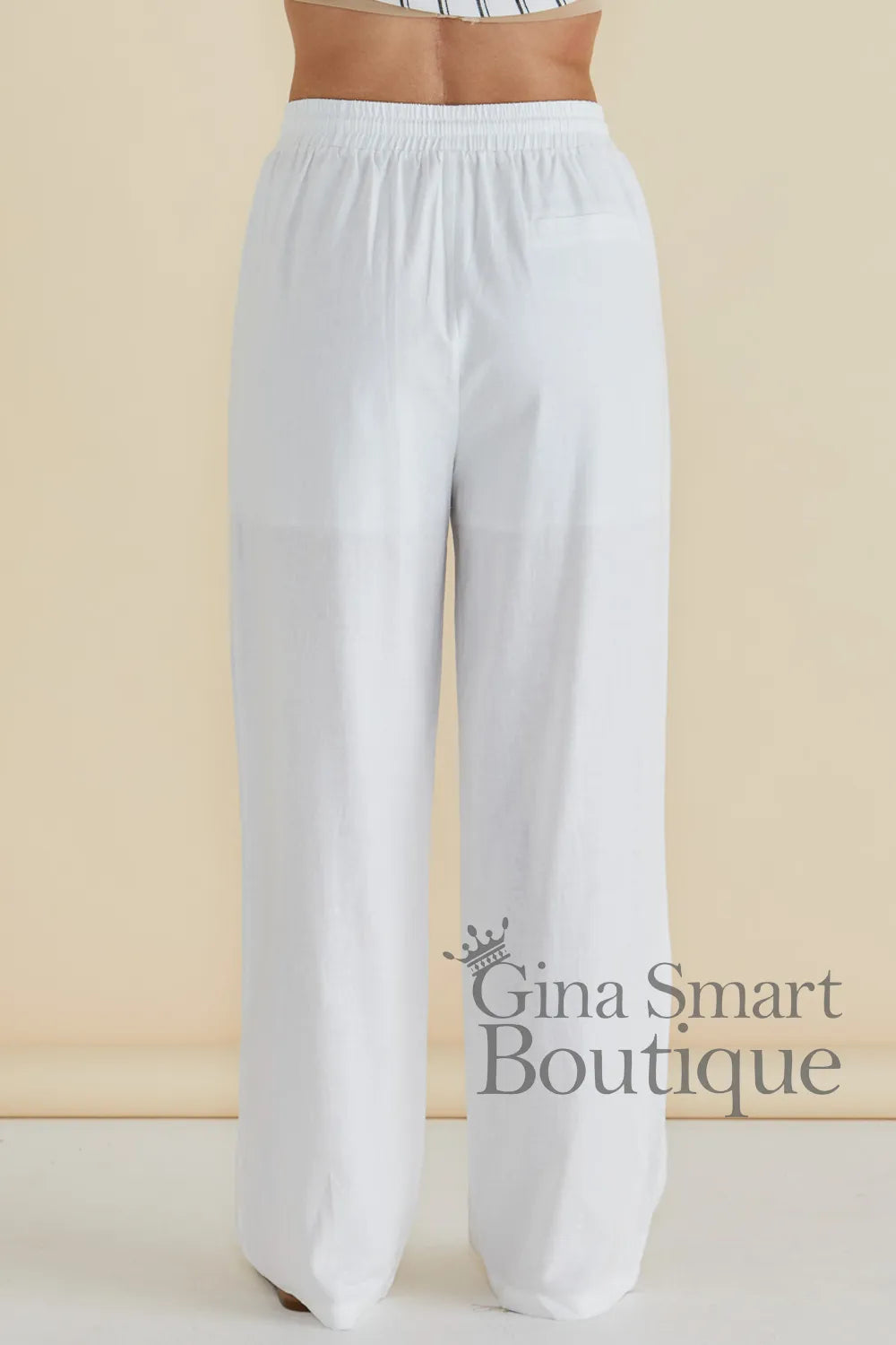 Betty Basics Zaza Relaxed Trouser back view is a white wide leg trouser with a comfortable elastic waistband.  Available at Gina Smart Boutique