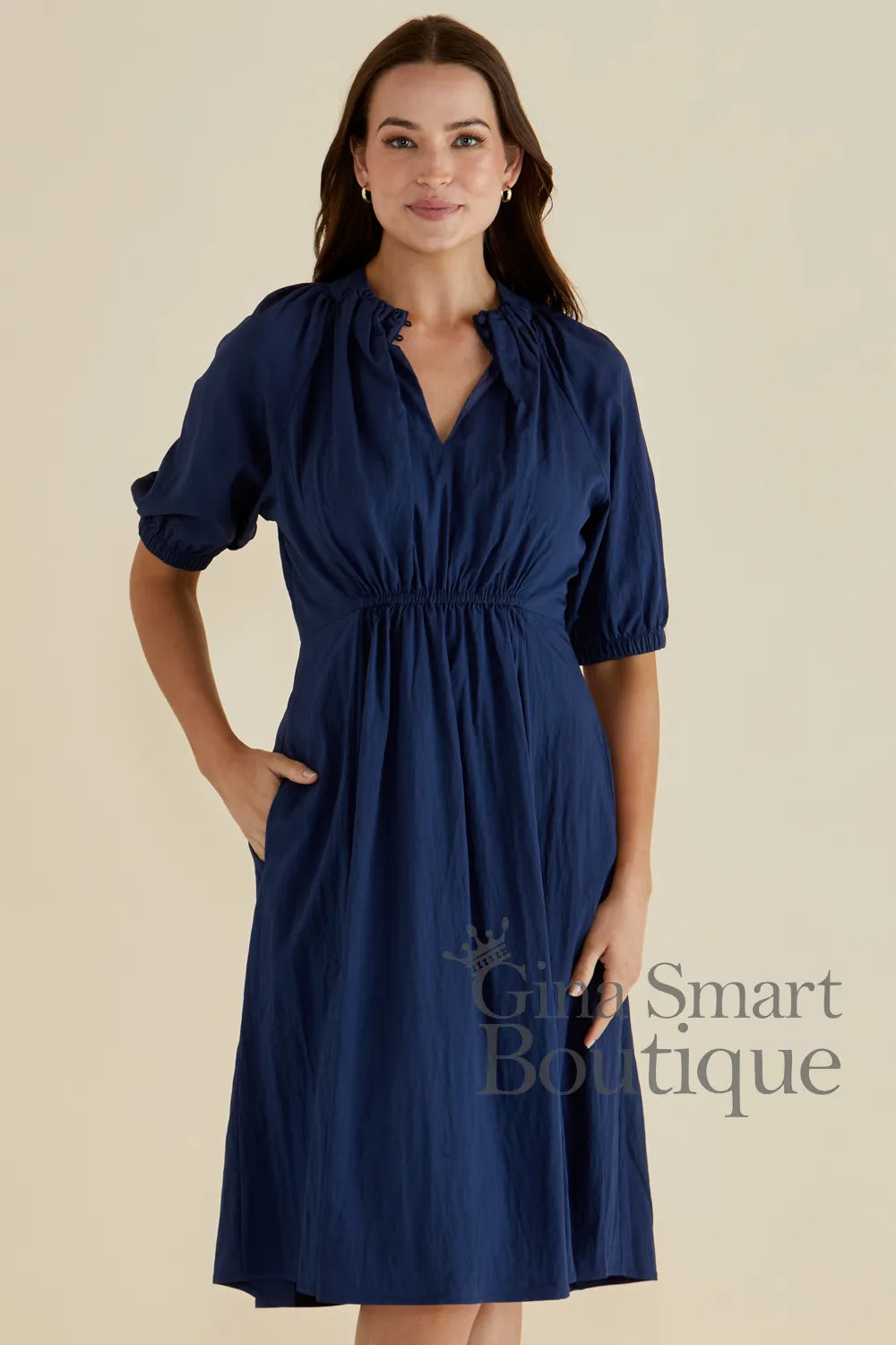 Betty Basics navy blue midi dress with puff sleeves and a smocked waist available at Gina Smart Boutique