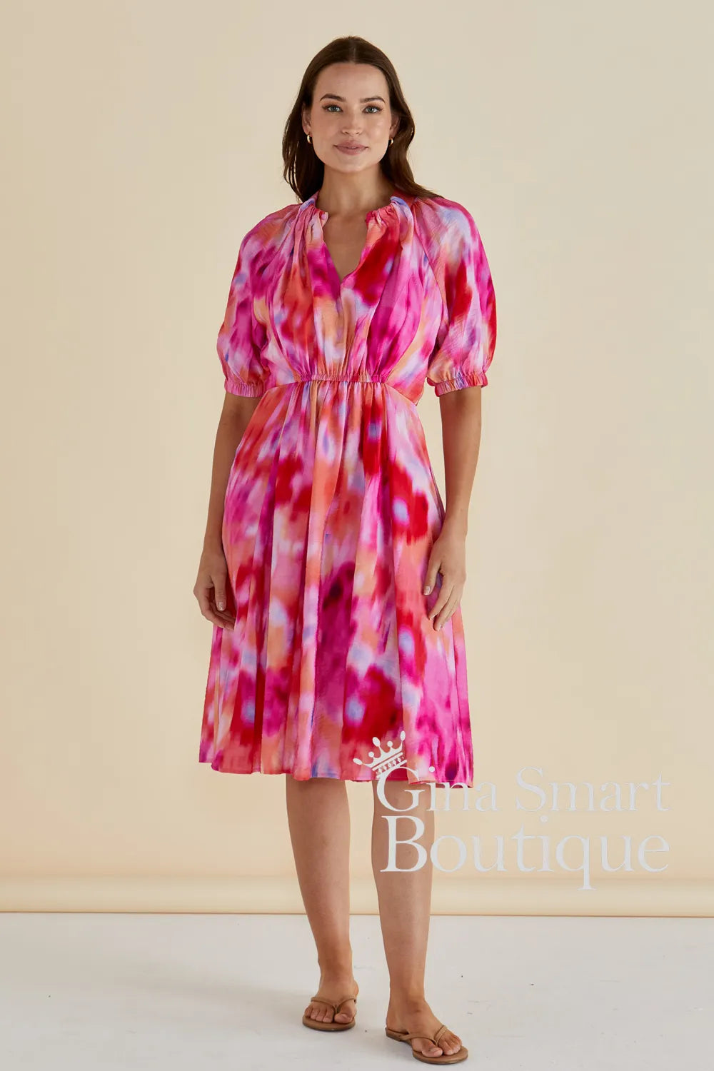 Betty Basics Emery Dress is a pink and red watercolour print midi dress with puff sleeves and a smocked waist.  Available from Gina Smart Boutique