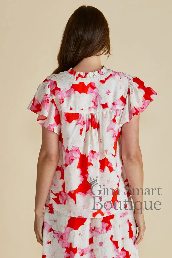 Betty Basics Lyra Blouse rear view is a red, pink and white floral print blouse with a V-neckline and ruffle cap sleeves - available at Gina Smart Boutique