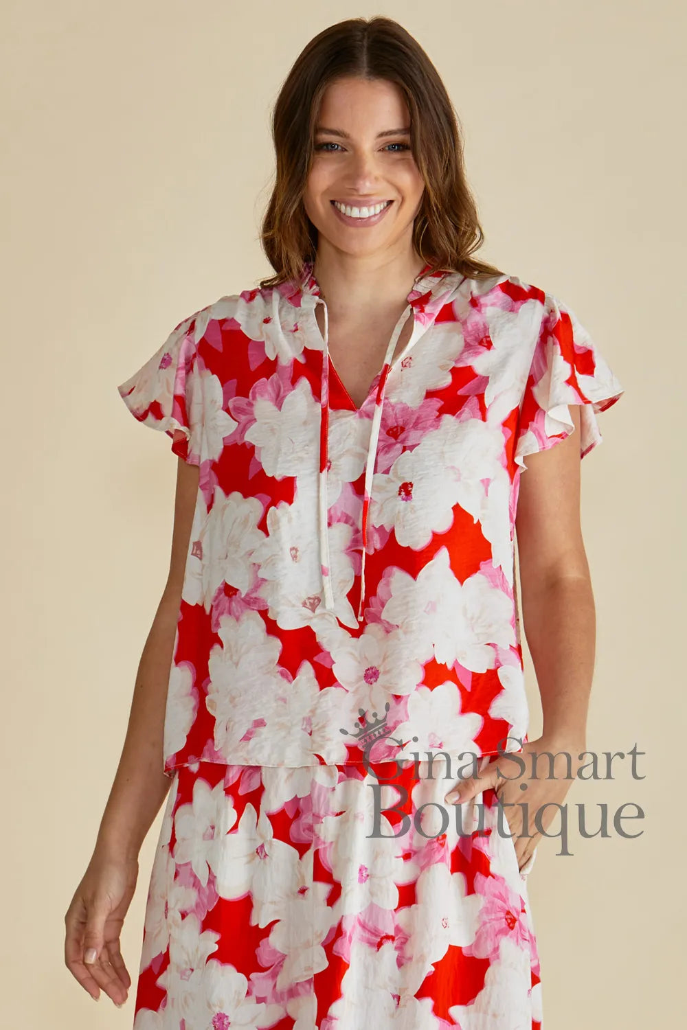 Betty Basics Lyra Blouse is a red, pink and white floral print blouse with a V-neckline and ruffle cap sleeves - available at Gina Smart Boutique
