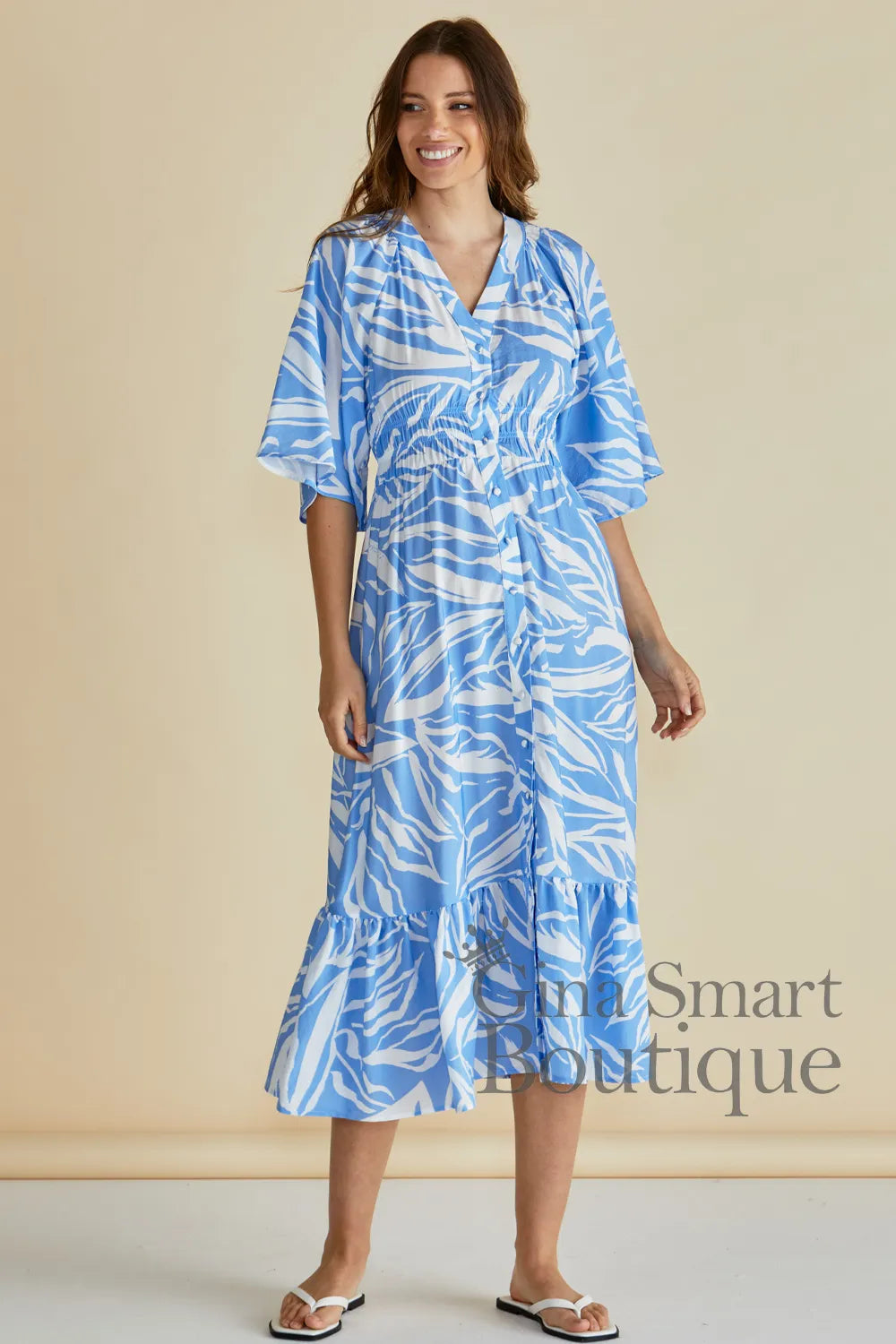 Betty Basics Moxie Dress is a blue and white leaf print midi dress with a smocked waist and button down front.  Available at Gina Smart Boutique.