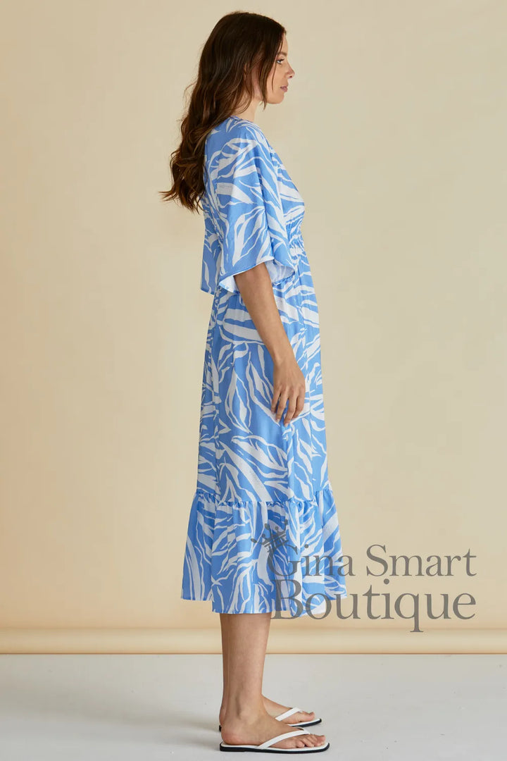 Betty Basics Moxie Dress side view is a blue and white leaf print midi dress with a smocked waist and button down front.  Available at Gina Smart 