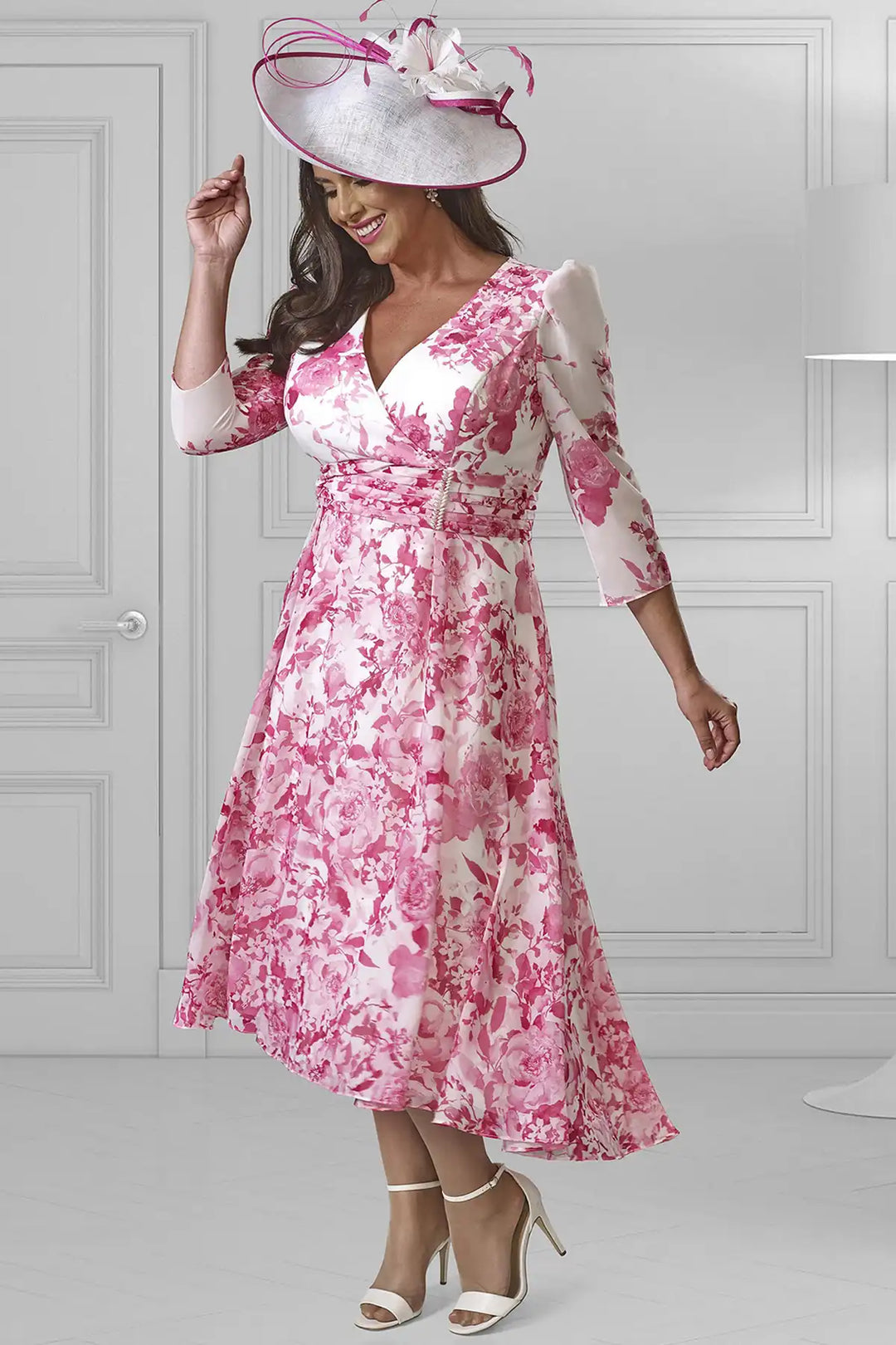 Elegant woman in a Dressed Up by Veromia DU594K A-line dress featuring a vibrant fuchsia and white floral print, V-neckline, and three-quarter sleeves.