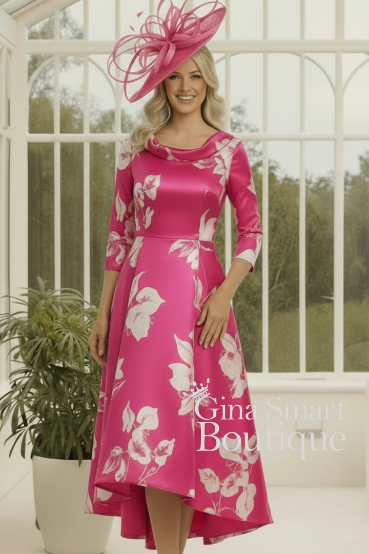 Woman wearing a pink floral dress with a matching hat in a decorative setting.