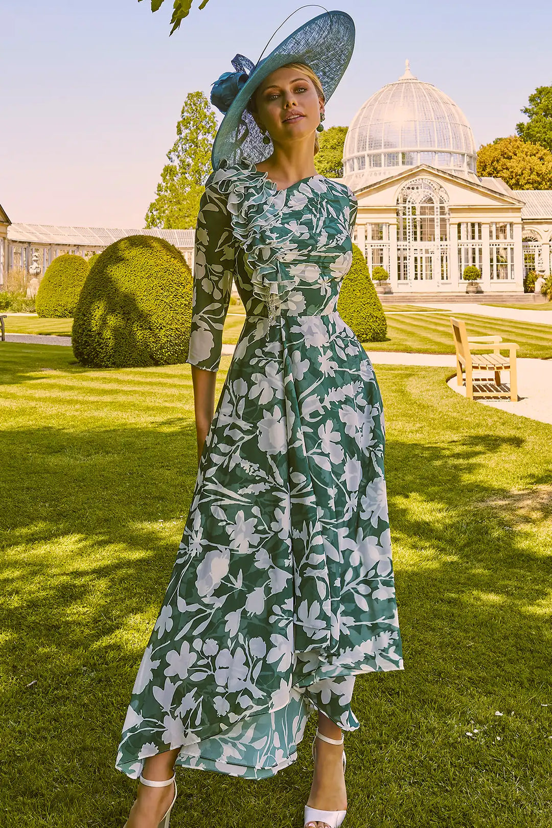 Elegant woman in Invitations by Veni 36021A shamrock green dress with ivory floral design and high-low skirt