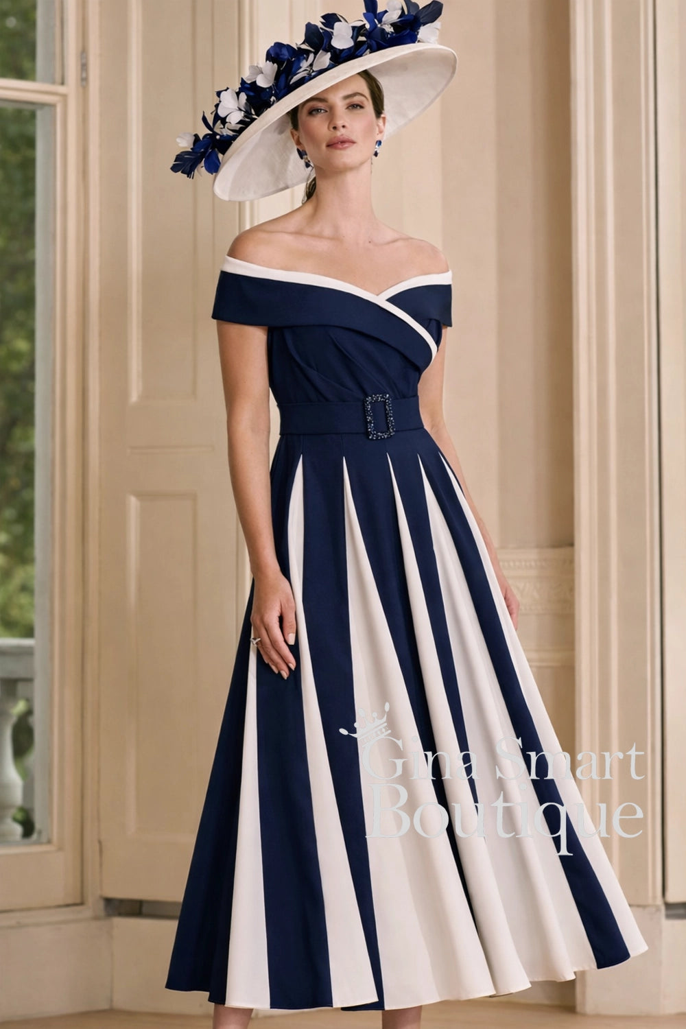 John Charles navy and ivory A-line dress with Bardot neckline, full pleated skirt, and matching hat – classic Mother of the Bride outfit.