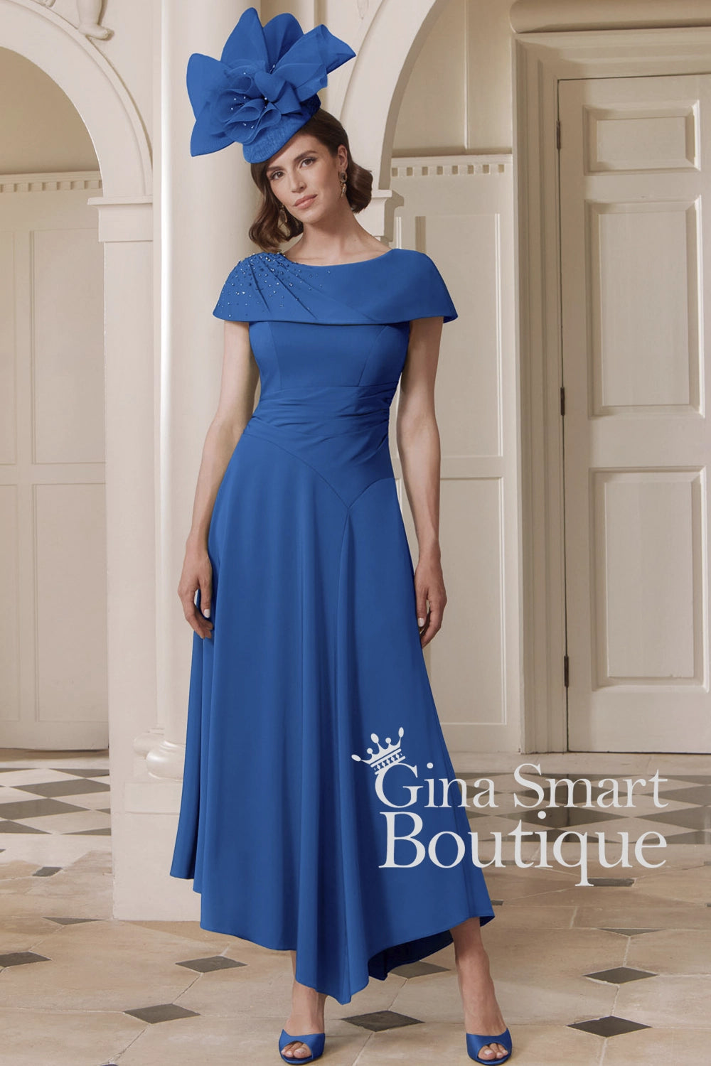 John Charles sapphire blue A-line dress with beaded Bardot neckline, ruched waist, and matching hat – regal Mother of the Bride outfit.