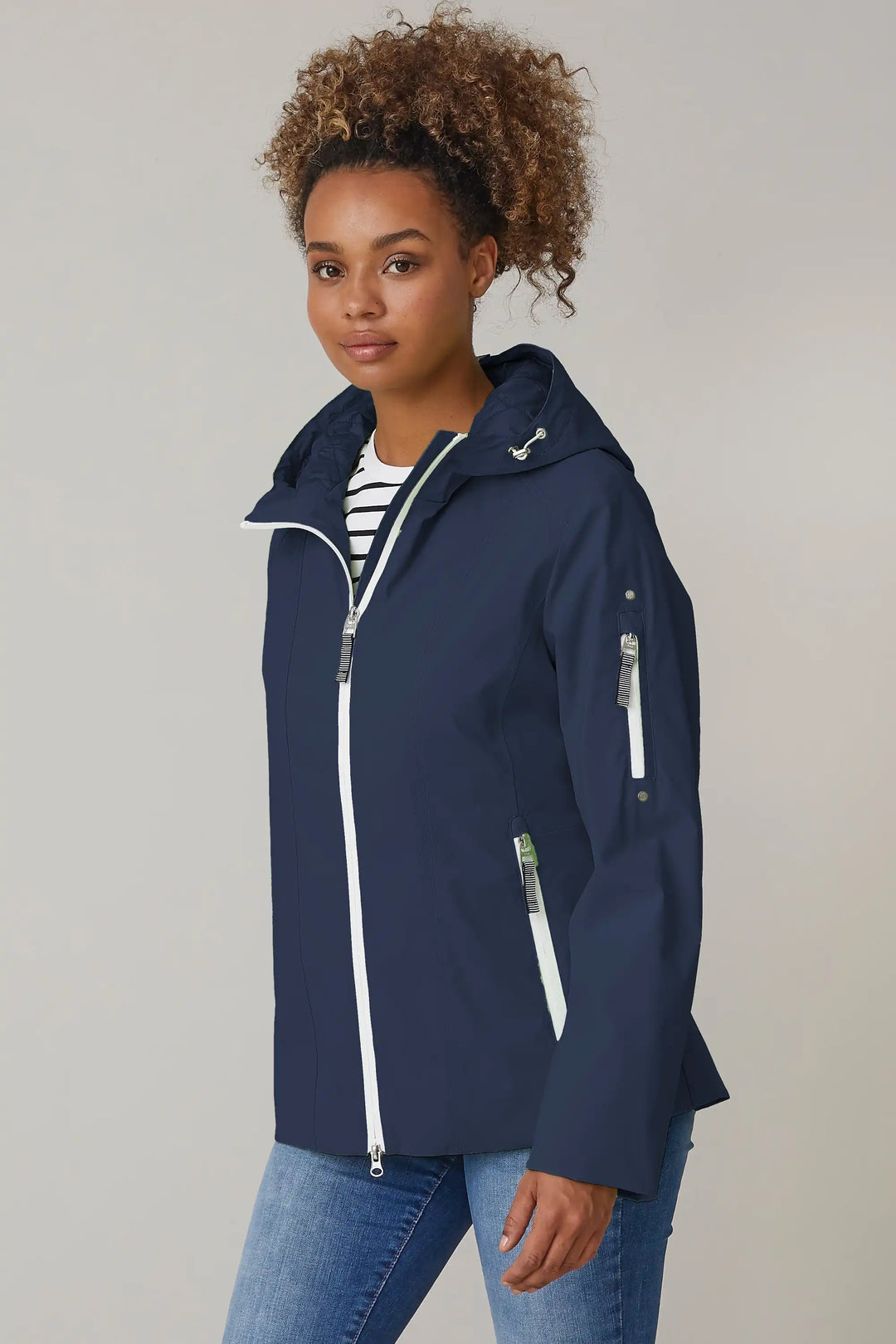 A model sports a navy windbreaker with a hood and zippered pockets, layered over a striped shirt for a casual, functional spring outfit, style 0124-2494-88-50